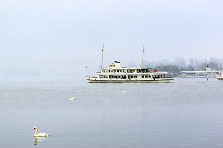 Boats take tourists to see the beauty in the lake Lucerne amid cold weather in winter, Switzerland.の写真素材