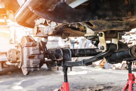 Old and rusty car's suspension, which removes the wheels for repair, replacement and change news parts -Automotive industry and garage concepts.の写真素材