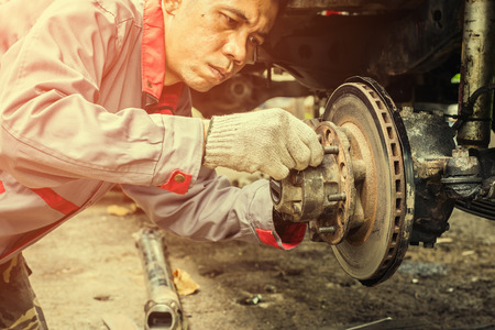 Technicians in grey uniform are repairing the brake of the car, Automotive industry and garage concepts.の写真素材