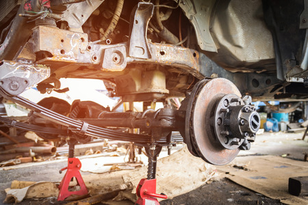 Old and rusty car's suspension, which removes the wheels for repair, replacement and change news parts -Automotive industry and garage concepts.の写真素材