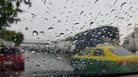 Closeup rain drops on the car's glass view from the inside of the car in a raining day.の写真素材