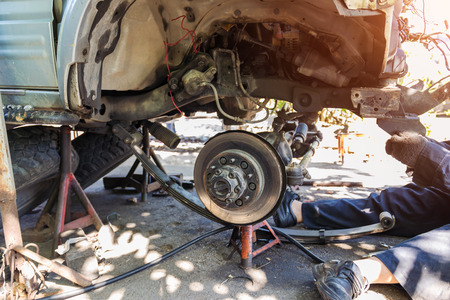 Technician are repairing the front and undercarriage crashes from the accident on the road parked in the garage. Concept for the automotive industry and insurance.の写真素材