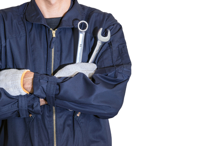 Car repairman wearing a dark blue uniform standing and holding a wrench that is an essential tool for a mechanic isolated on white background.の写真素材