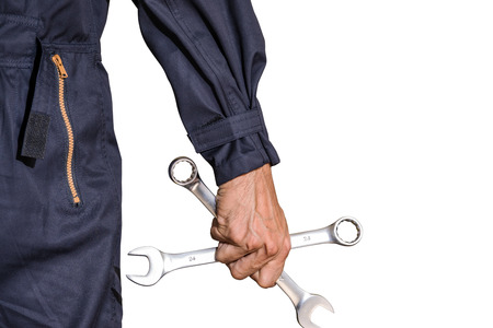 Car repairman wearing a dark blue uniform standing and holding a wrench that is an essential tool for a mechanic isolated on white background, Automotive industry and garage concepts.の写真素材