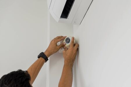 Technicians are installing a cctv camera on the roof, can connect to the Internet, and control the camera via a smartphone or tablet.の写真素材