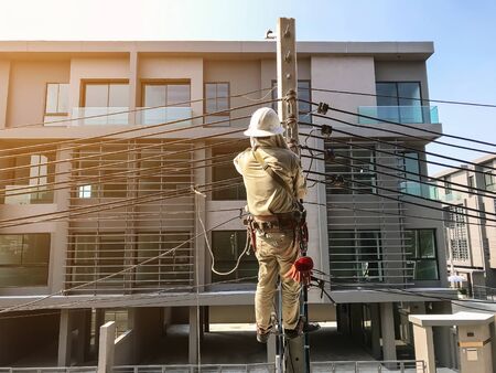 Electricians are climbing on electric poles to install power lines.