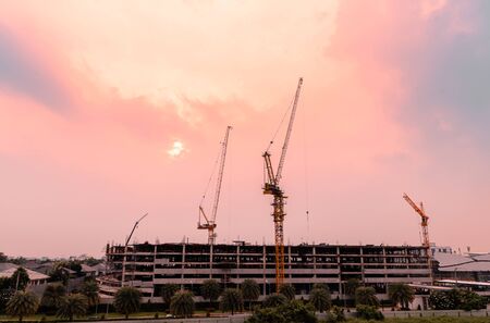Heavy lifting cranes are important machinery and tools in the construction industry, with beautiful sky in the twilight time.の写真素材