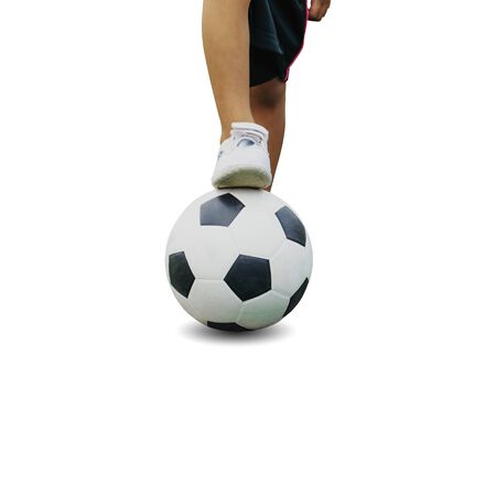 The boy in sportswear wearing sneakers is stepping on a soccer ball isolated on white backgroundの写真素材