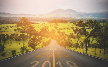 Closeup the number 2020 symbol represents the new year on the road heading to the mountain in the forest, New Year's and business target concepts.の写真素材
