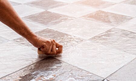 Men's hands are used to convert polishing cleaning on the tile floor.の写真素材