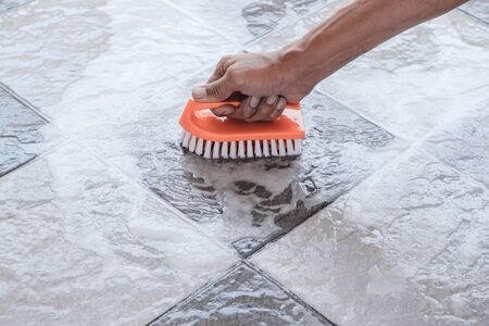 Hand of man is used to convert polishing cleaning on the tile floor.の写真素材