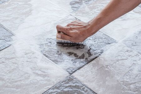 Men's hands are used to convert polishing cleaning on the tile floor.の写真素材