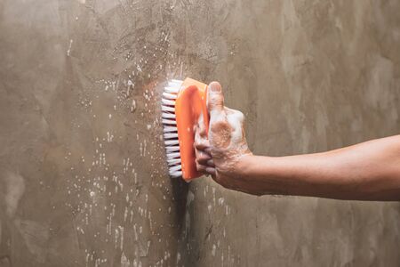 Men's hands are used to convert polishing cleaning on the concrete wall.の写真素材