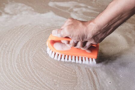 Men's hands are used to convert polishing cleaning on the tile floor.の写真素材
