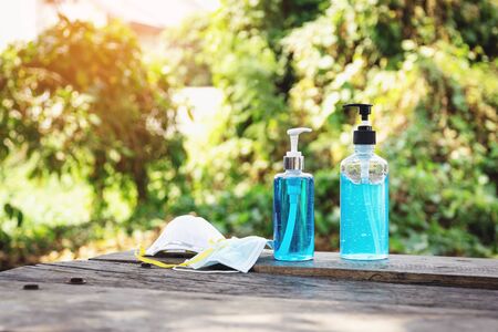 Sanitary mask and alcohol gel for hand washing and cleaning on a wooden table is essential to help prevent infection and spread of the virus.の写真素材
