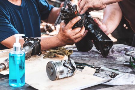 Technicians are helping to assemble the car power steering gearbox.の写真素材