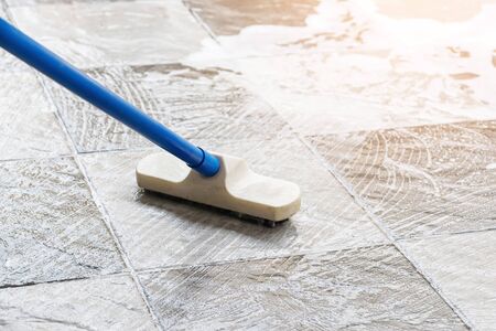 Cleaning the tile floor with floor scrubber brush and water.の写真素材