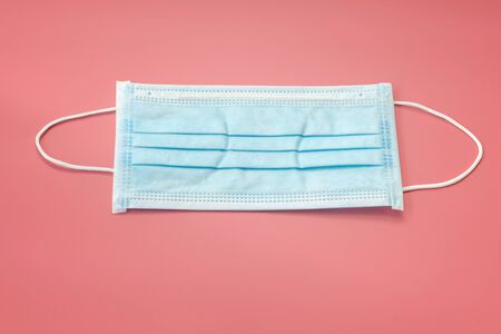 Sanitary napkin mask for preventing spreading and respiratory infections isolated on red pastel background, Stop Coronavirus Covid-19 concept.の写真素材