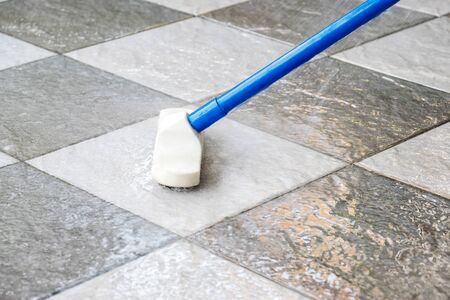 Cleaning the tile floor with floor scrubber brush.の写真素材