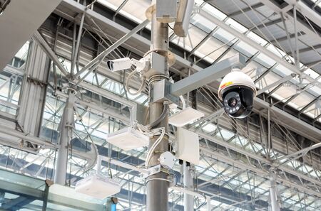 CCTV cameras, wireless signal distribution equipment and speakers mounted on poles inside the building.の写真素材