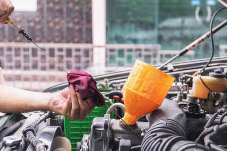 Cars mechanic is checking the level of engine oil from the engine oil level gauge of the car, Automotive industry and garage concepts.の写真素材