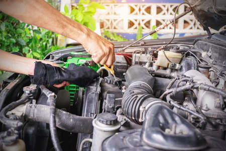 Cars mechanic is checking the level of engine oil from the engine oil level gauge of the car, Automotive industry and garage concepts.の写真素材