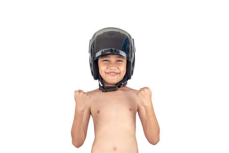 A boy wearing a motorcycle helmet stands smiling but without a shirt isolated on white background.の写真素材