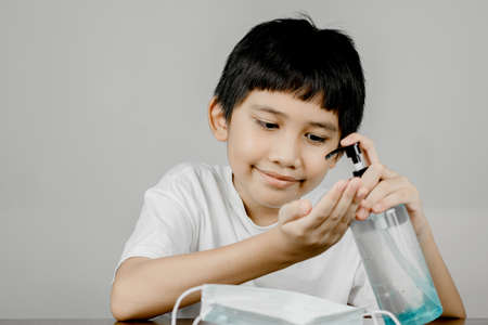 Closeup of a boy face washing his hands with alcohol gel.の写真素材