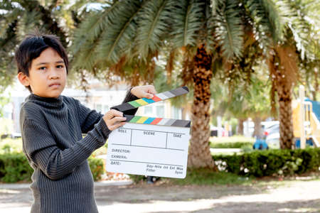 Asian boy holding film slate colors board for movie cinema and television industryの写真素材