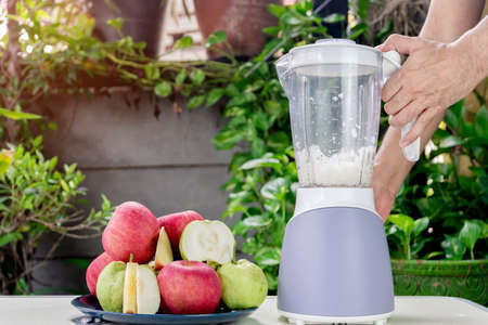 Hand of people are using an electric blender to making fresh apple and guava juice.の写真素材