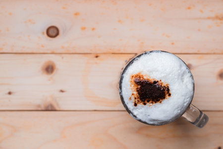 Top view of iced coffee froth in coffee mug cup on wooden floor.の写真素材