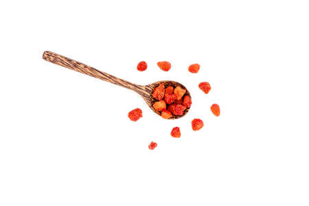 Group of dried strawberries in a wooden spoon isolated on white background.の写真素材