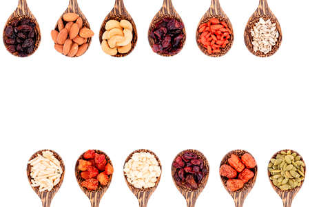 Top view group of whole grains and dried fruits 12 kinds on wooden spoons with copy space isolated on white background.の写真素材