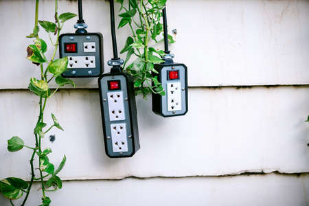Closeup group of silver colors trailer plug  with on-off switch hanging on the wall.の写真素材