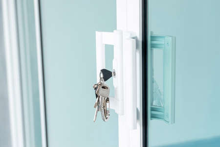 Close-up of the key ring plugged into the glass door.の写真素材