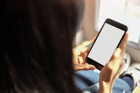 Cropped shot view of man hands holding smart phone with blank copy space screen for your text message or information content, female reading text message on cell telephone during in urban setting. の写真素材