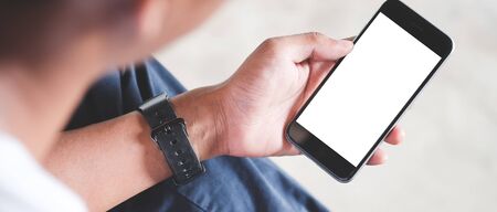 Cropped shot view of man hands holding smart phone with blank copy space screen for your text...