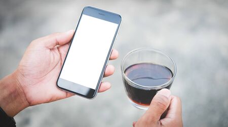 Cropped shot view of man hands holding smart phone with blank copy space screen for your text message or information content, female reading text message on cell telephone during in urban setting. の写真素材