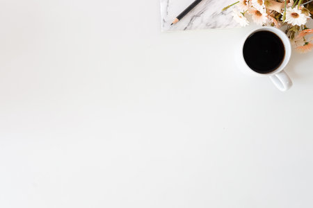 Top view office desk with coffee cup, keyboard, glasses and supplies.の写真素材