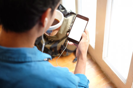 Mock up smartphone of hand holding black mobile phone with blank white screen.の写真素材