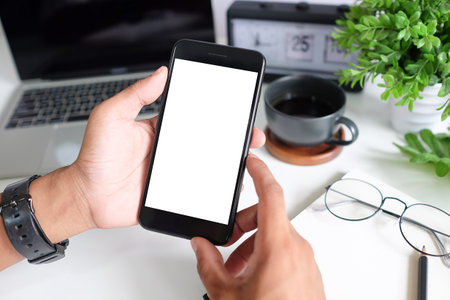 Cropped shot view of man hands holding smart phone with blank copy space screen for your text message or information content, female reading text message on cell telephone during in urban setting.の写真素材