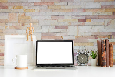 Work place with blank screen computer pc and office supplies on white table with brick wall in vintage office.の写真素材