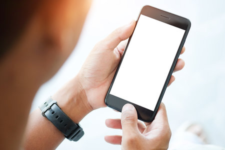 Cropped shot view of man hands holding smart phone with blank copy space screen for your text message or information content, female reading text message on cell telephone during in urban setting.の写真素材