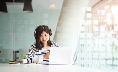 Experienced businesswoman reading publication via laptop computer making research for planning startup at desktop in modern office.の写真素材