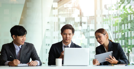 Business team brainstorming and discussing with financial data and technology equipment. Teamwork meeting working concept.の写真素材