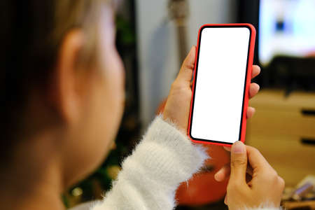 Close up view of young woman hands holding mock up smart phone with blank white screen at her...