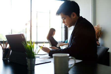 Business people analysing and discussing online data with laptop computer in office.の写真素材