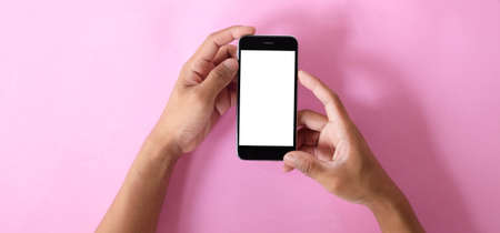 Close up shot of man hands holding mobile phone with blank screen on black background with copy space.の写真素材