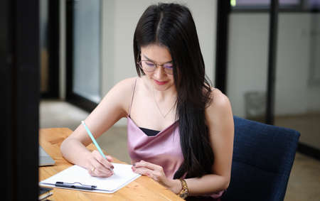 Experienced businesswoman reading publication via laptop computer making research for planning startup at desktop in modern office.の写真素材