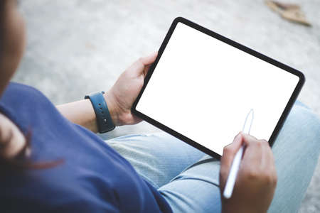 Close up of business man handing hold tablet with white screen on office desk.